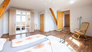 A bedroom with a bed, a rocking chair, and a wardrobe. - Heritage Apartment in Battenberg near Skiing (Battenberg)