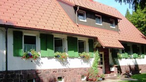 A two-story building with a red-tiled roof, green shutters, and flower boxes on the windowsills. - Apartment in Tabarz Near Thuringian Forest (Waltershausen)
