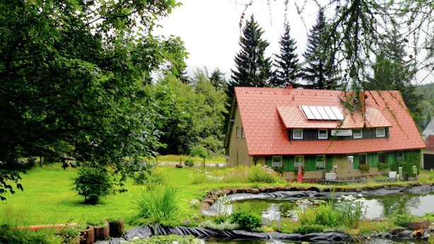A house with a red roof and a pond in front. - Apartment in Tabarz Near Thuringian Forest (Waltershausen)