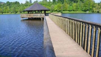 Un molo di legno che si protende su un lago, con un gazebo all'estremità.