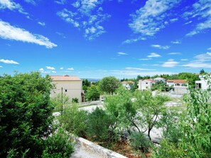 A residential area with houses, a clear blue sky, and green trees.