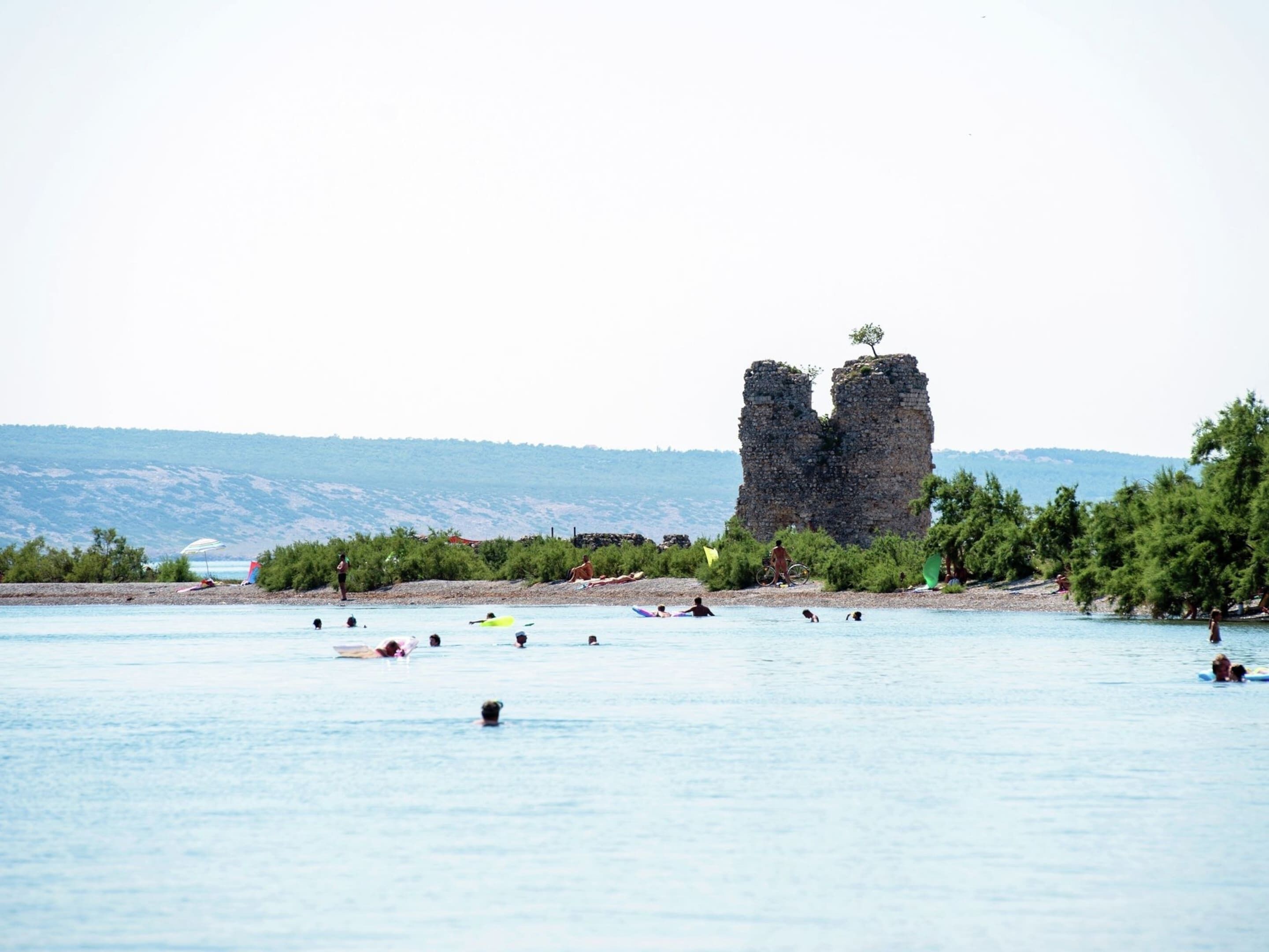 A beach with a prominent rock formation in the background.