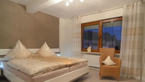 A bedroom with a bed, a chair, a window, and a radiator. - Ferienhaus Paula in Haserich im Hunsrueck (Haserich)