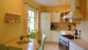 Una cocina compacta con una mesa, sillas y electrodomésticos esenciales.