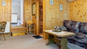A wooden interior with a sofa, a table, a chair, and a radiator. - Attractive Apartment in Rubeland in the Upper Harz (Oberharz am Brocken)