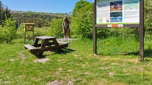 A picnic table and a bear statue in a park with a signboard in the foreground. - Attractive Apartment in Rubeland in the Upper Harz (Oberharz am Brocken)