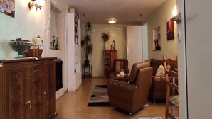 A living room with a brown leather sofa, a wooden cabinet, and a dining area with a table and chairs. - Apartment in Wehlen by Moselle Vineyards (Bernkastel-Kues)