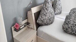 A neatly made bed with patterned pillows, a bedside table with a lamp, and a small decorative item. - Apartment in Wehlen by Moselle Vineyards (Bernkastel-Kues)
