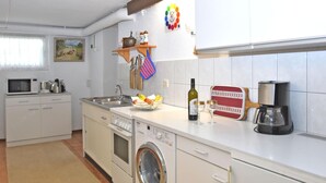 A compact kitchen with a washing machine, a microwave, and a coffee maker. - Flat in Bellenberg With Sunbathing Lawn (Horn-Bad Meinberg)