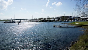 A marina with boats docked, a grassy area, and a clear sky. - Holiday Home in Kortgene Near Lake Veere (Kortgene)