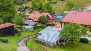 A residential area with houses, a greenhouse, and a paved pathway. - Quiet Home Near Vessertal (Schleusegrund)