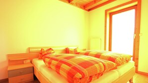 A bedroom with a bed, bedside tables, and a wooden floor. - Spacious Apartment in Mittersill near Ski Points (Mittersill)