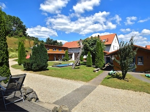A residential property with a gravel driveway, a swimming pool, and a patio area with outdoor furniture.