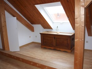 A room with a sloped ceiling, a skylight, and a wooden cabinet.