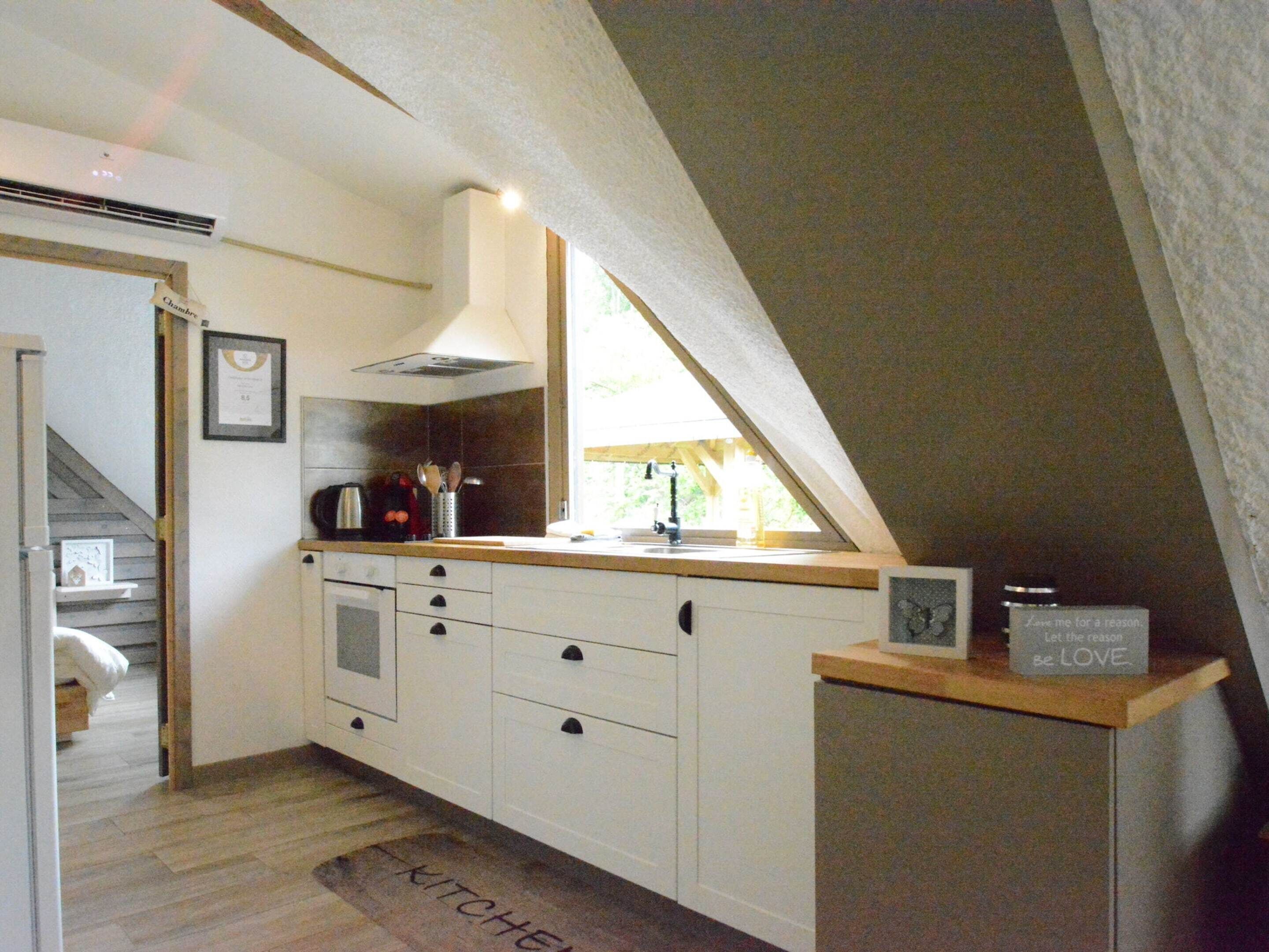 A kitchen with white cabinets, a stove, and a window.