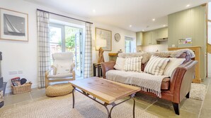 A cozy living room with a sofa, armchair, and a wooden coffee table.