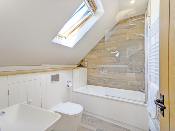 A modern bathroom with a skylight, a bathtub, a toilet, and a shower area. - Hearnesbrook Barn , Emsworth - an annexe that sleeps 4 guests in 2 bedrooms (Emsworth)