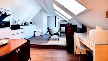 Experience a bright and airy loft-style living space with a skylight, modern kitchen, and dining area.