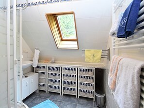 A compact bathroom with a window, a sink, a toilet, and storage baskets. - Apartment in Wildemann Near Hahnenklee Ski Area (Clausthal-Zellerfeld)