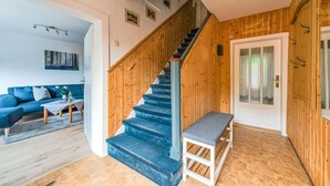 Una escalera con barandillas de madera que conduce a una puerta con paneles de vidrio esmerilado.