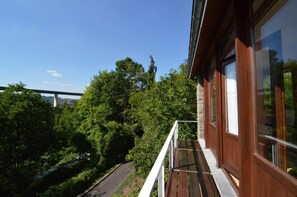 A balcony with a view of a bridge and dense greenery. - A Small Studio of a Nature Stone House (Aywaille)