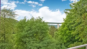 A lush green forest with a bridge in the background. - A Small Studio of a Nature Stone House (Aywaille)