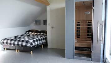 Une chambre à coucher comprenant un lit, une armoire et un placard intégré avec des étagères.