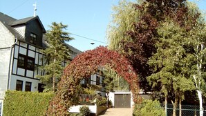 A residential area with a house featuring a traditional design, a driveway, and a fenced yard. - Apartment in a Former Farmhouse (Mastershausen)