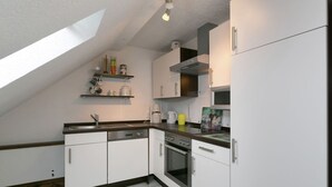 A modern kitchen with white cabinets, a built-in oven, and a coffee maker. - Apartment in a Former Farmhouse (Mastershausen)