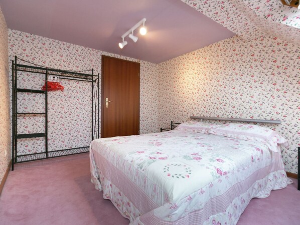 A bedroom with floral wallpaper, a bunk bed, a wooden door, and a ceiling light fixture. - Apartment in a Former Farmhouse (Mastershausen)