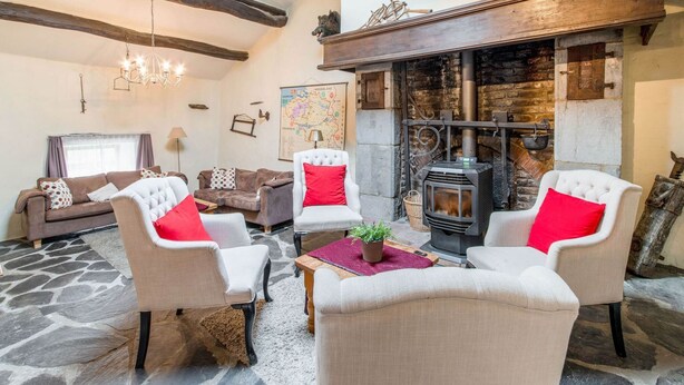 A cozy living room with a stone floor, a fireplace, and modern furniture. - Characteristic Holiday Home With Balcony (Gouvy)