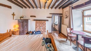 A cozy room with a bed, a small table, a chair, a dresser, and a window with a view. - Characteristic Holiday Home With Balcony (Gouvy)