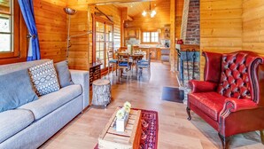 Ein Holzblockhaus-Innenraum mit Wohnbereich, Essbereich und Küche.