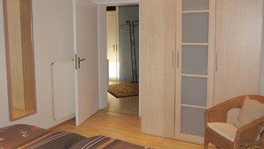 Une chambre à coucher avec un lit, une armoire et une chaise.