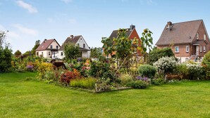 A residential area with houses, a well-maintained garden, and a clear sky.
