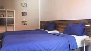 A bedroom with two beds, a wooden headboard, a white wardrobe, and a small side table. - Wohnung in Tabarz Thuringen in Waldnahe (Tabarz)