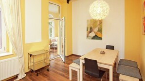 A dining area with a wooden table, chairs, a hanging light fixture, and a painting on the wall. - Peaceful Villa in Borstendorf (Grünhainichen)