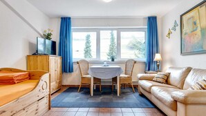A cozy room with a bed, a sofa, a dining table, and a TV. - Apartment in Lennestadt for 2 Person (Lennestadt)