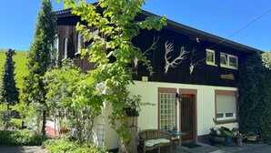 A two-story building with a garden entrance, a wooden bench, and a door with a window. - Apartment in Lennestadt for 2 Person (Lennestadt)