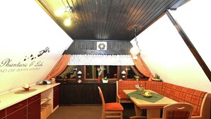 Ein gemütlicher Essbereich mit Holzboden, einer Bar und einer Sitzgruppe mit Tisch und Stühlen.
