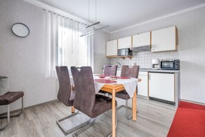Uma cozinha moderna com armários brancos, micro-ondas e forno embutido.