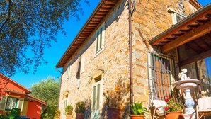 A stone building with a tiled roof, potted plants, and a fountain. - Amazing Farmhouse in Montecatini Terme with Hot Tub (Pieve a Nievole)