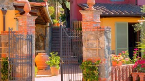A traditional stone gate with a metal fence, a brick wall, and a tiled roof. - Amazing Farmhouse in Montecatini Terme with Hot Tub (Pieve a Nievole)