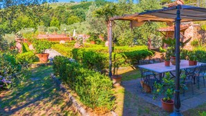 A garden patio with a pergola, outdoor seating, and a view of a lush landscape. - Amazing Farmhouse in Montecatini Terme with Hot Tub (Pieve a Nievole)