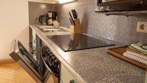 A modern kitchen with a dishwasher, stove, and microwave. - Charming Home in Winterstein (Waltershausen)