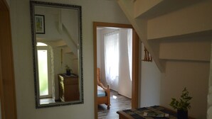 A hallway with a large mirror, a wooden dresser, and a staircase leading to another room. - Holiday Home in the Eifel With Balcony (Bremm)