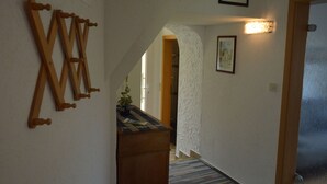A hallway with a wooden bench, a textured wall, and a framed picture. - Holiday Home in the Eifel With Balcony (Bremm)