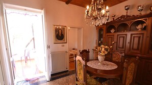 A dining area with a wooden table, chairs, a chandelier, and a cabinet with decorative items. - Holiday Home in Rio Near Fishing Villages (Sesta Godano)