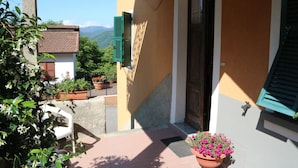 A balcony with a potted plant, a door, and a view of mountains. - Holiday Home in Rio Near Fishing Villages (Sesta Godano)