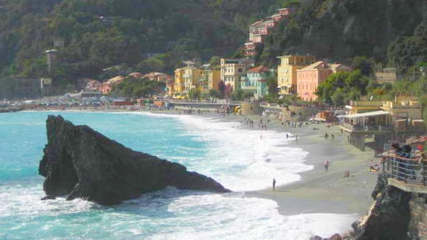 A coastal town with colorful buildings along the beach, rocky cliffs, and waves crashing onto the shore. - Holiday Home in Rio Near Fishing Villages (Sesta Godano)